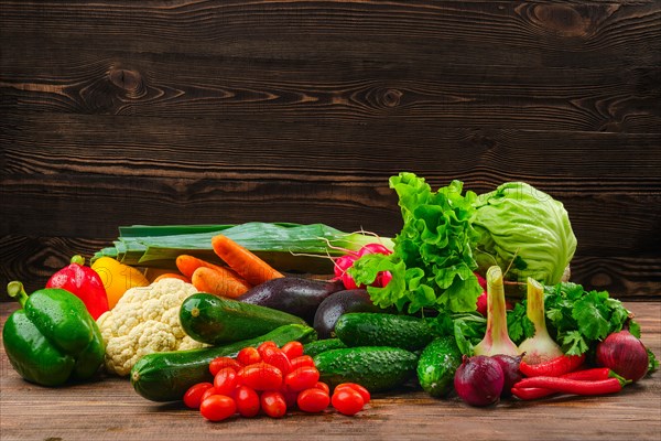 Assortment of fresh vegetables on dark wooden background