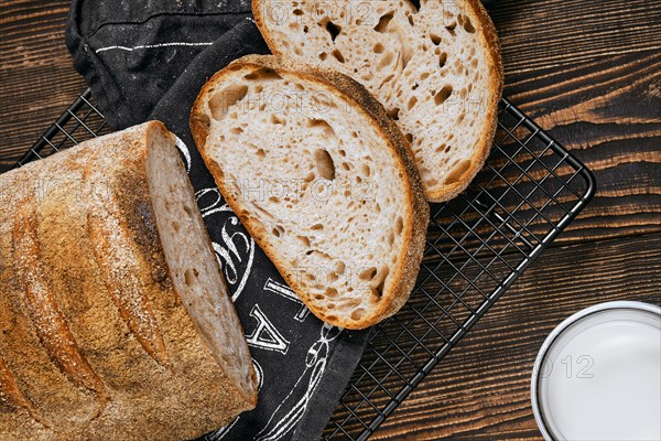 Closeup view of loaf of artisan sourdough bread with porous texture on wooden table