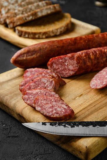 Closeup view of smoked pork sausage rings on wooden cutting board on kitchen table