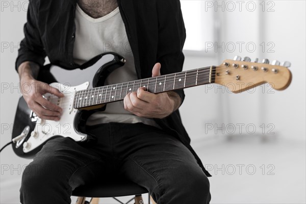 Front view male musician playing electric guitar