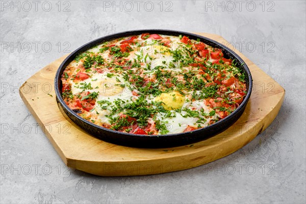 Eggs with tomato baked in oven in cast-iron skillet