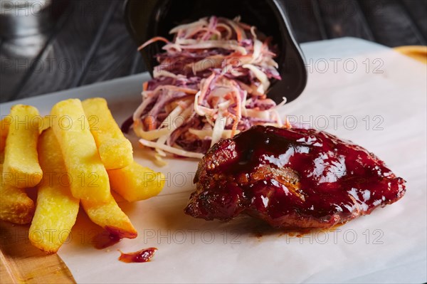 Rustic lunch. Grilled ribs with fried potato and red cabbage salad