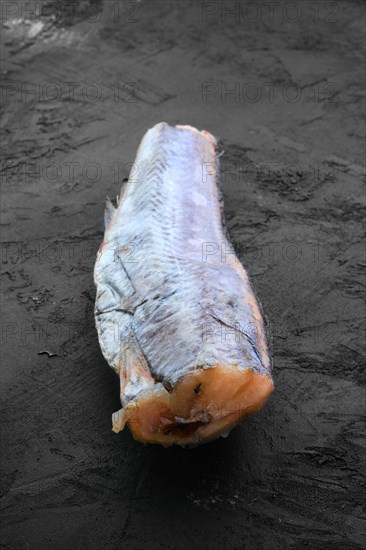 Frozen raw pollock carcass on wooden background