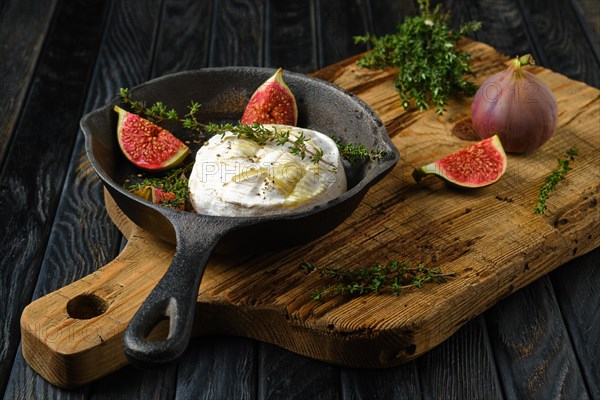 Top view of baked in oven soft cheese and figs on frying pan