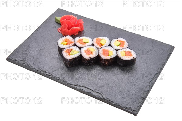 Rolls with salmon and avocado on slate plate isolated on white