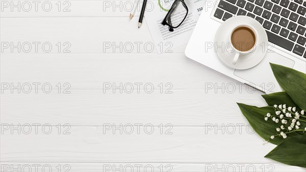 Overhead view spiral notepad laptop with coffee cup desk