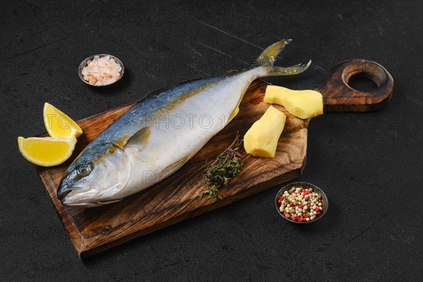 Raw fresh yellow tailed lacedra on wooden cutting board