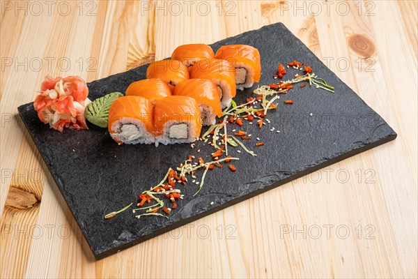 Set of rolls with wasabi and pickled ginger on stone serving board