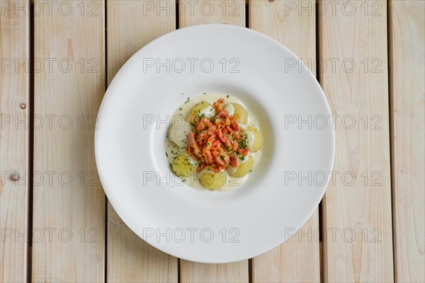 Top view of potato dumplings with bacon on wooden table