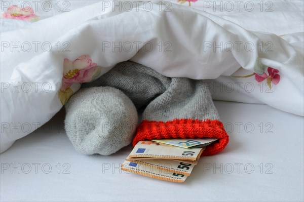 Banknotes in stocking under duvet