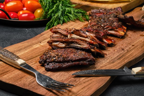 Top view of grilled lamb breast ribs on wooden cutting board