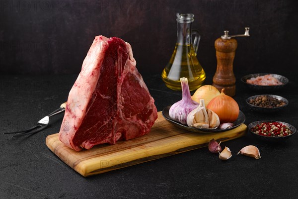 Raw porterhouse steak with spice and seasoning ready for cooking