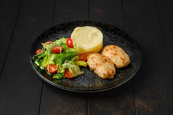 Meat cutlet with mashed potato and fresh vegetables on a plate