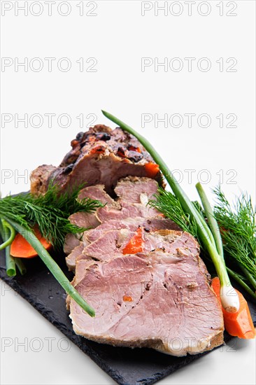 Baked ham decorated with fresh vegetables isolated on white background