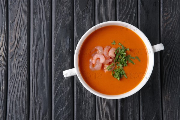 Top view of rustic tomato soup with shrimps