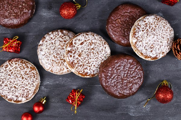 German round gingerbread called Lebkuchen with white and chocolate glazing surrounded by seasonal Christmas decoration