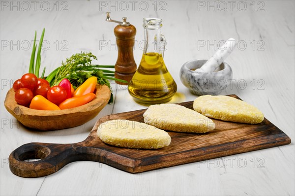 Semifinished homemade zander cutlet on a wooden serving board