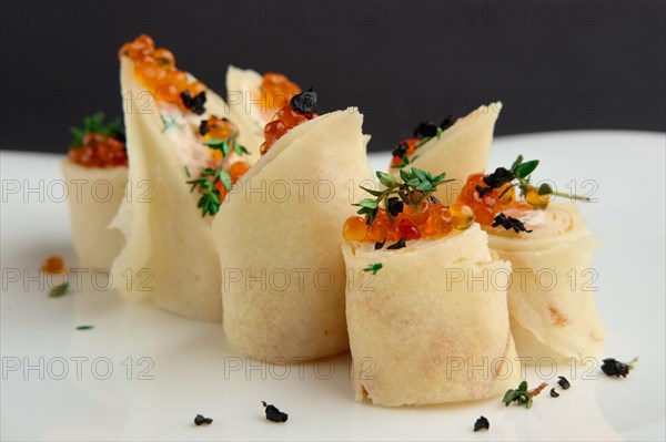 Close up view of pancakes with salmon and caviar on big white plate