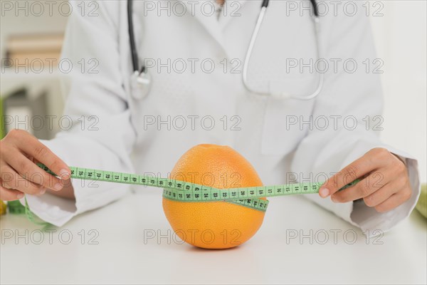 Close up nutritionist measuring orange