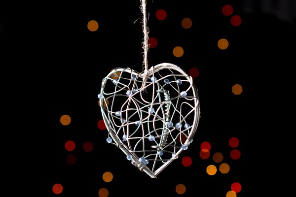 Heart shaped metal cage on a bokeh light background