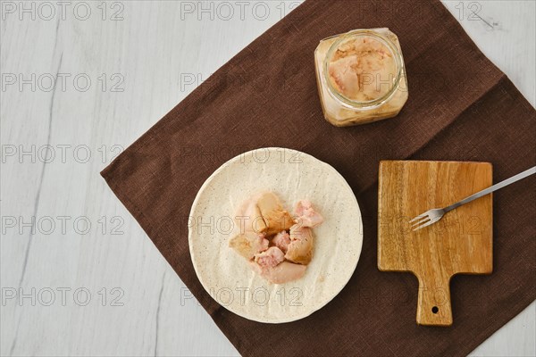 Top view of canned cod liver in glass pot on the table