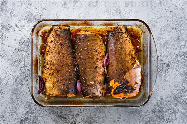 Top view of pan with red salmon baked in oven with spice