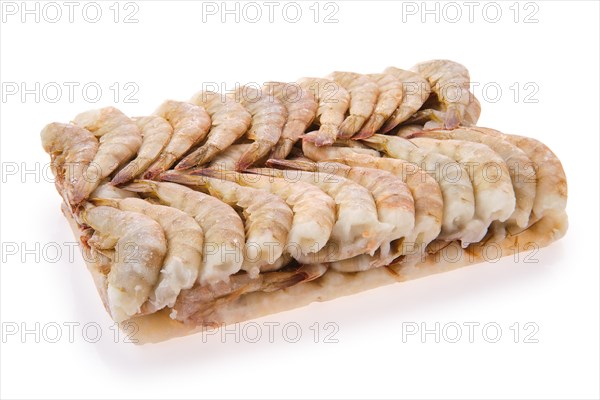 Raw tiger shrimp frozen in large ice cube isolated on white background