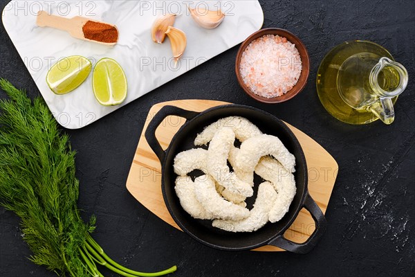 Top view of prepared for frying uncooked shrimps in cheese breading with spice