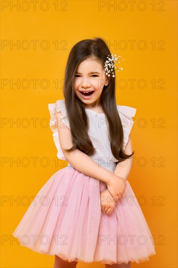 Portrait of laughing little child on bright yellow background