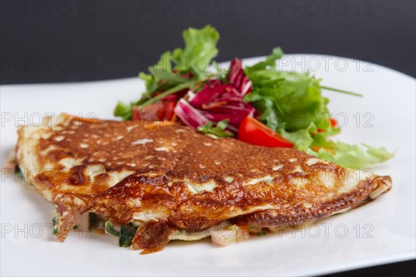 Closeup of omelet with ham and vegetables on a plate