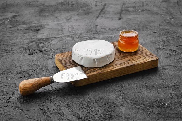 Piece of soft brie or camembert cheese on cutting board