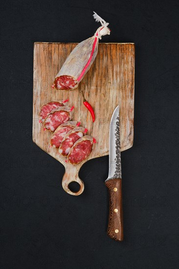 Top view of sliced dry beef sausage on cutting board
