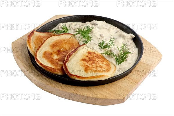 Flapjack with mushroom sauce on wooden plate