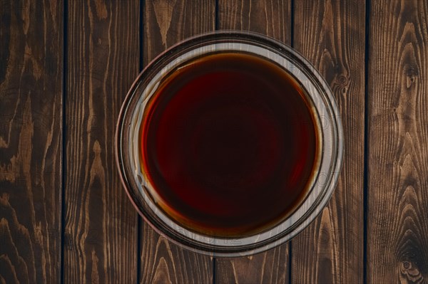 Top view of plate with soy sauce on wooden table