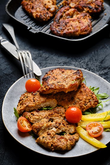 Pork chop fillet baked in oven with seasoning and herbs