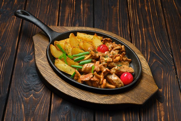 Potato pancakes with chanterelles and pork in cast iron skillet