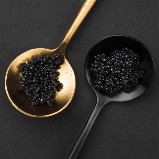 Golden and black spoon with caviar