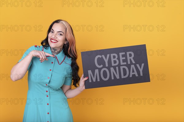 Beautiful woman pointing at a Cyber Monday sign. Commercial concept. Commerce