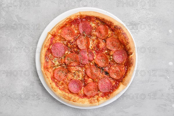 Overhead view of small size pizza pepperoni on a plate