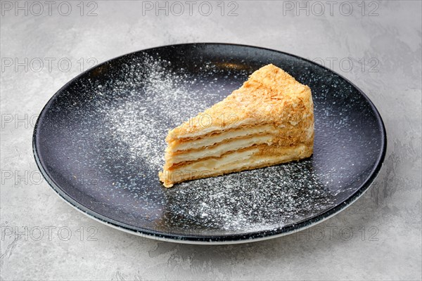 Triangular piece of classic Napoleon cake on a plate
