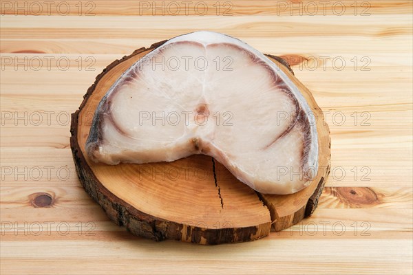 Frozen blue shark steak on wooden table