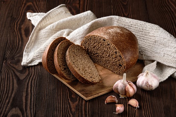 Brown garlic bread on cutting board on the table