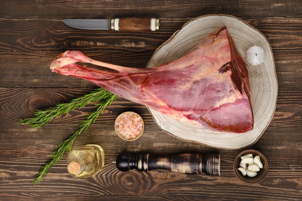 Raw fresh young beef leg on wooden background