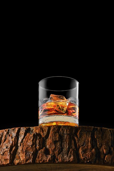 Bottom view at the glass with single malt whiskey with ice