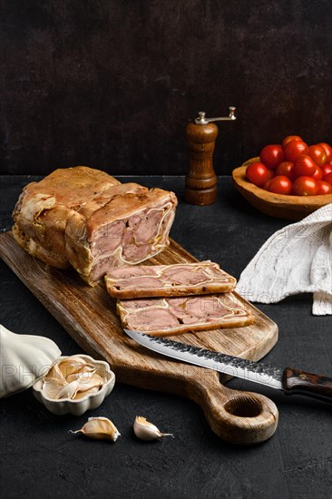 Boiled beef tongue roll on wooden cutting board