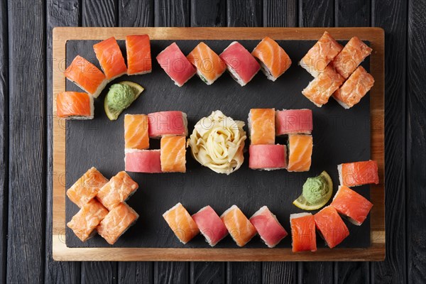 Big set of rolls served on stone plate. Layout for menu