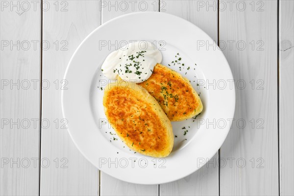 Top view of traditional belarussian potato cakes with sour cream