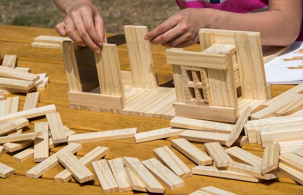 Hand holding wooden puzzle element in hand