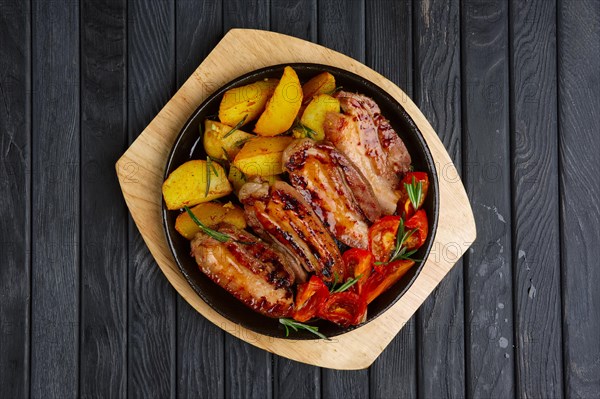 Fried meat on rib with potato and tomato