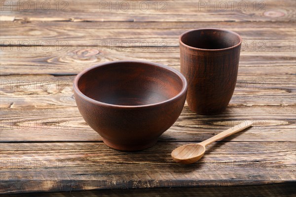 Set of clay dishes with tablecloth on wooden table